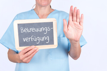 Altenpflegerin oder Krankenschwester mit einer Tafel auf der Betreuungsverfügung steht