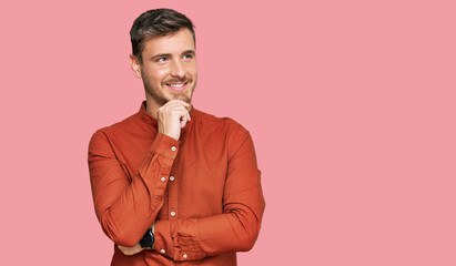 Fototapeta premium Handsome caucasian man wearing casual clothes with hand on chin thinking about question, pensive expression. smiling with thoughtful face. doubt concept.