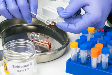Hematological analysis with forensic test kit in a murder in a crime lab, conceptual image