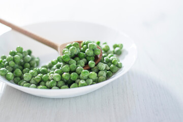 green peas in a white plate on a white background