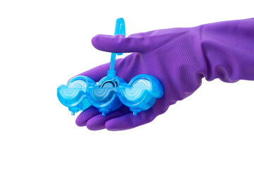 Person in purple protective rubber gloves holds multi-colored balls of toilet bowl cleaner. isolated on white background isolation. Selective focus, close-up