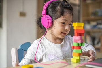 Asian girl learning from headphone and laptop, Happy girl learn online with laptop at home.