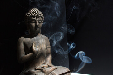 Buddha statue with incense stick meditating people home practice mindfulness yoga meditation...