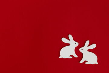 Happy Easter! Easter decoration - Easter bunnies on a bright red background.