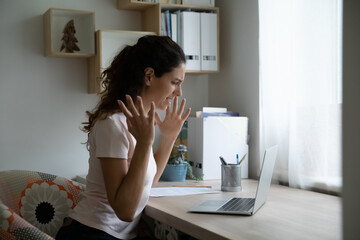 Angry millennial female freelancer feeling mad cursing in panic losing data files as result of...