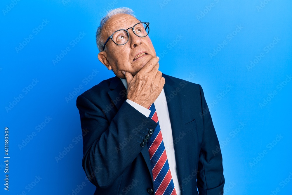 Poster Senior caucasian man wearing business suit and tie thinking worried about a question, concerned and nervous with hand on chin