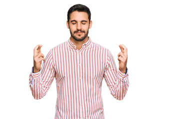 Young hispanic man wearing business shirt gesturing finger crossed smiling with hope and eyes closed. luck and superstitious concept.