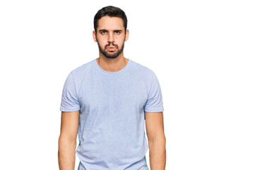 Obraz premium Young hispanic man wearing casual clothes puffing cheeks with funny face. mouth inflated with air, crazy expression.