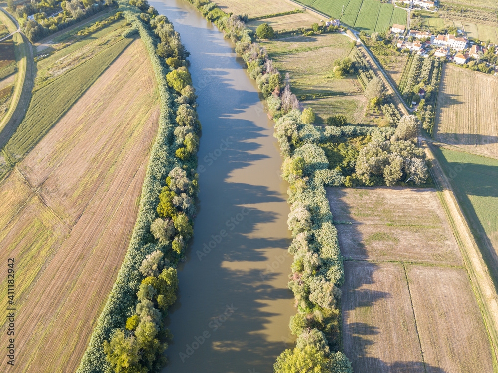 Wall mural aerial view of river arno between cultivated fields