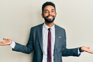 Handsome hispanic man with beard wearing business suit and tie smiling showing both hands open palms, presenting and advertising comparison and balance