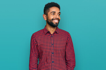 Young african american man wearing casual clothes looking away to side with smile on face, natural expression. laughing confident.