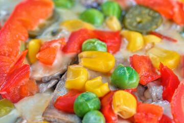 Closeup of delicious fresh local hot pizza with tomatoes, maize, green pea and paprika