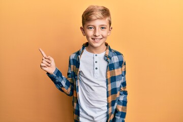 Little caucasian boy kid wearing casual clothes smiling happy pointing with hand and finger to the side