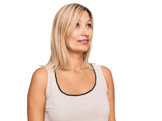 Fototapeta premium Middle age caucasian woman wearing casual clothes looking away to side with smile on face, natural expression. laughing confident.