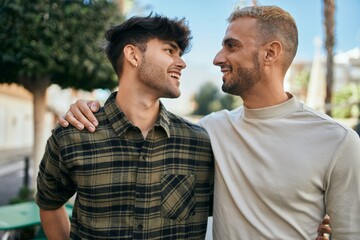 Young gay couple smiling happy and hugging at the city.