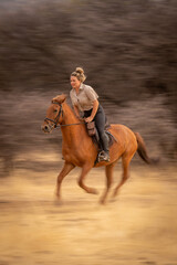 Slow pan of blonde riding past bushes