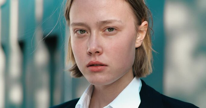 Close-up Portrait of a nice-looking Student or Businessperson, elegant young Female is looking into the Camera. Career People. Natural Beauty. Female portraits. Stylish Blonde Haircut.
