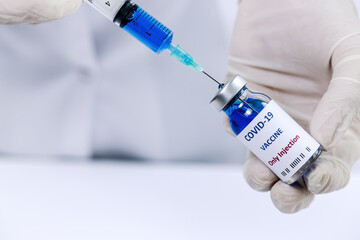 COVID-19 vaccine in researcher hands, unrecognizable female doctor holds syringe