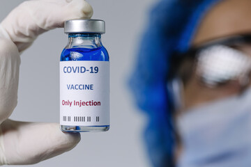 COVID-19 vaccine in researcher hands, unrecognizable female doctor holds syringe