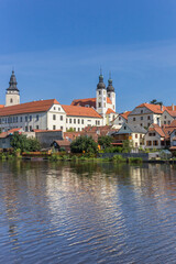 Skyline with towers and old houses reflected in the lake in Telc, Czech Republic