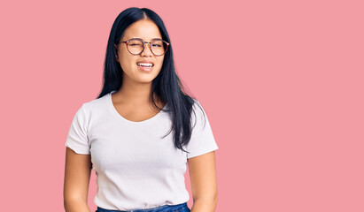 Young beautiful asian girl wearing casual clothes and glasses winking looking at the camera with...
