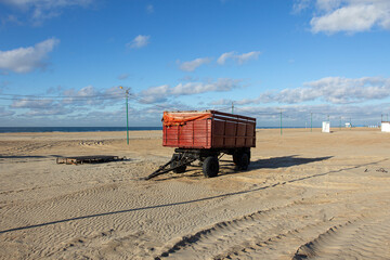 abandoned rusty trailer on a sandy beach in the off season