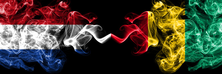 Netherlands vs Guinea smoky mystic flags placed side by side. Thick colored silky abstract smoke flags.