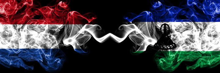 Netherlands vs Lesotho smoky mystic flags placed side by side. Thick colored silky abstract smoke flags.