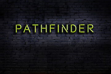 Neon sign. Word pathfinder against brick wall. Night view
