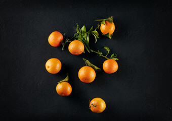 Tangerines with leaves on a black background