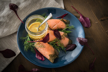 Gravlax Graved Lachs mit Rote Beete Blätter Salat, Dill, Rævesovs Senf Soße auf dunkel blau...