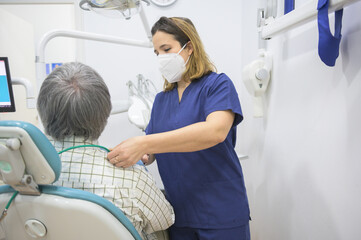 Female dentist wearing sanitary mask prepares her patient for dental checkup.Dental health care and businesswoman concept.