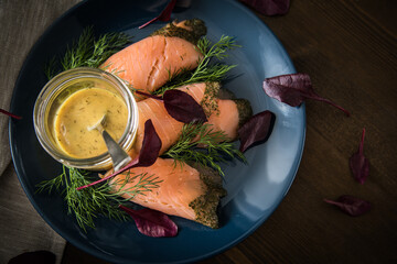 Gravlax Graved Lachs mit Rote Beete Blätter Salat, Dill, Rævesovs Senf Soße auf dunkel blau...