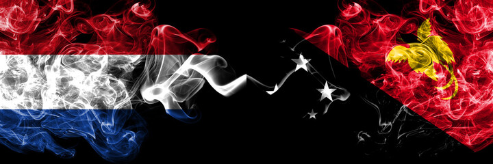 Netherlands vs Papua New Guinea smoky mystic flags placed side by side. Thick colored silky abstract smoke flags.