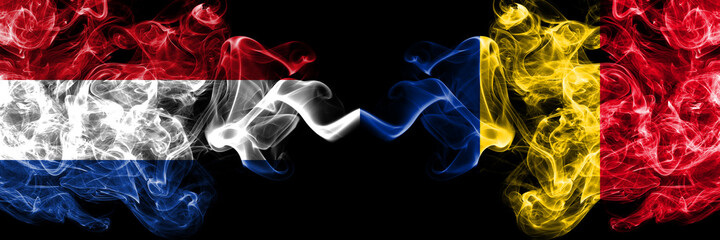 Obraz premium Netherlands vs Romania, Romanian smoky mystic flags placed side by side. Thick colored silky abstract smoke flags.