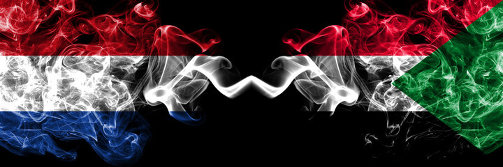 Netherlands vs Sudan smoky mystic flags placed side by side. Thick colored silky abstract smoke flags.