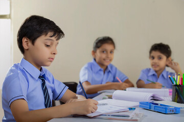students writing in their notebooks in class	