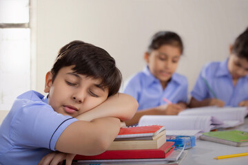 school boy sleeping in class 	