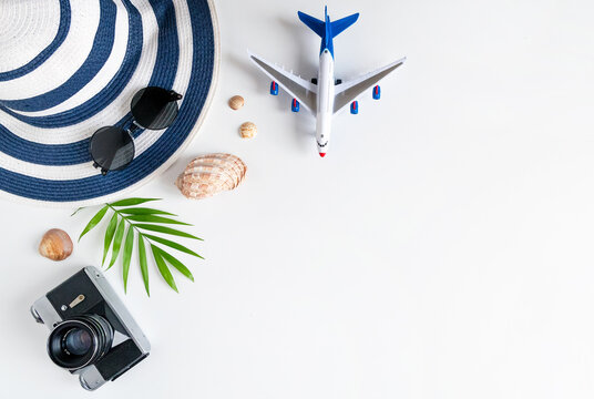 Things for summer holidays: a camera, shells, an airplane, sunglasses, a hat, a palm tree.