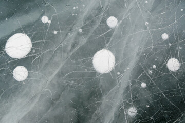 White air bubbles in ice. Abstract stripes and surface scratches.