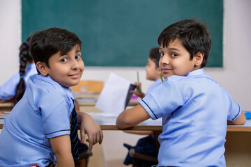 school boys sitting  in class and smiling	