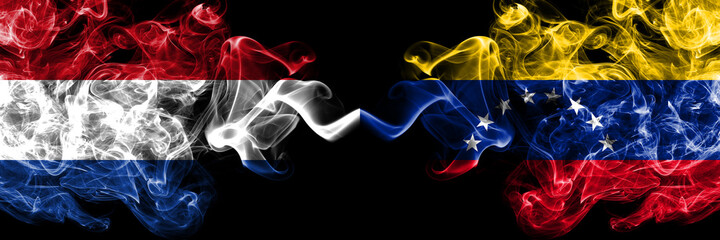 Netherlands vs Venezuela smoky mystic flags placed side by side. Thick colored silky abstract smoke flags.