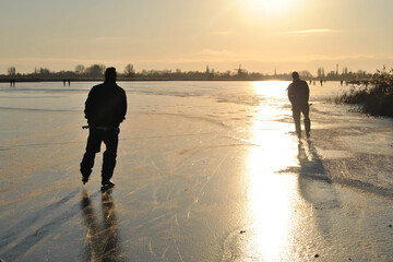 skating ice on the lake in the sunset late afternoon