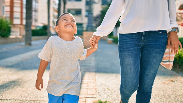 Adorable latin mother and son walking at the city.