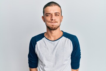 Hispanic young man wearing casual clothes puffing cheeks with funny face. mouth inflated with air, crazy expression.