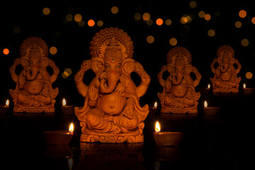 lord ganesha idols with diyas in front	