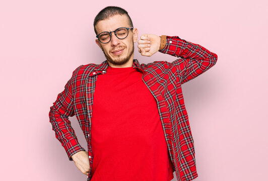 Hispanic young man wearing casual clothes stretching back, tired and relaxed, sleepy and yawning for early morning