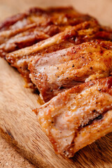 fried with spices pork ribs in a glass baking sheet on a wooden cutting board. cooked meat at home. Barbecue.