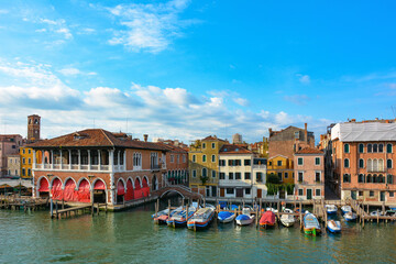 Boats moored in front of buildings along the Grand Canal in Venice in Italy.