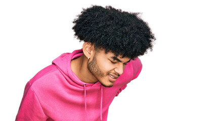 Young african american man with afro hair wearing casual pink sweatshirt suffering of backache, touching back with hand, muscular pain